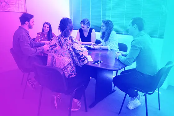 Groupe d'employés ENI échangeant autour d'une table pour partager leurs approches de pédagogie