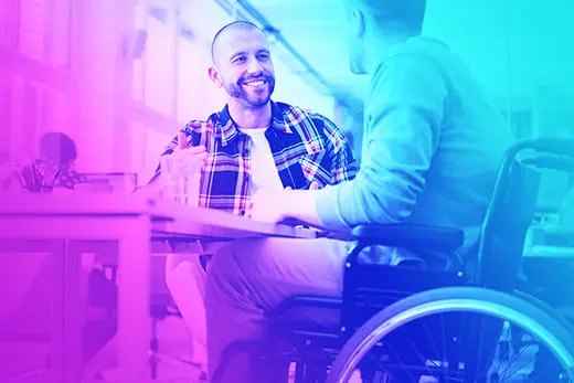 Homme en fauteuil roulant discutant avec un référent handicap à un bureau